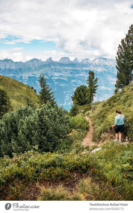Woman hiking on a narrow path in front of a mountain panorama hike Switzerland Clouds Mountain Alps mountains Clouds in the sky Panorama (View) Sky Nature