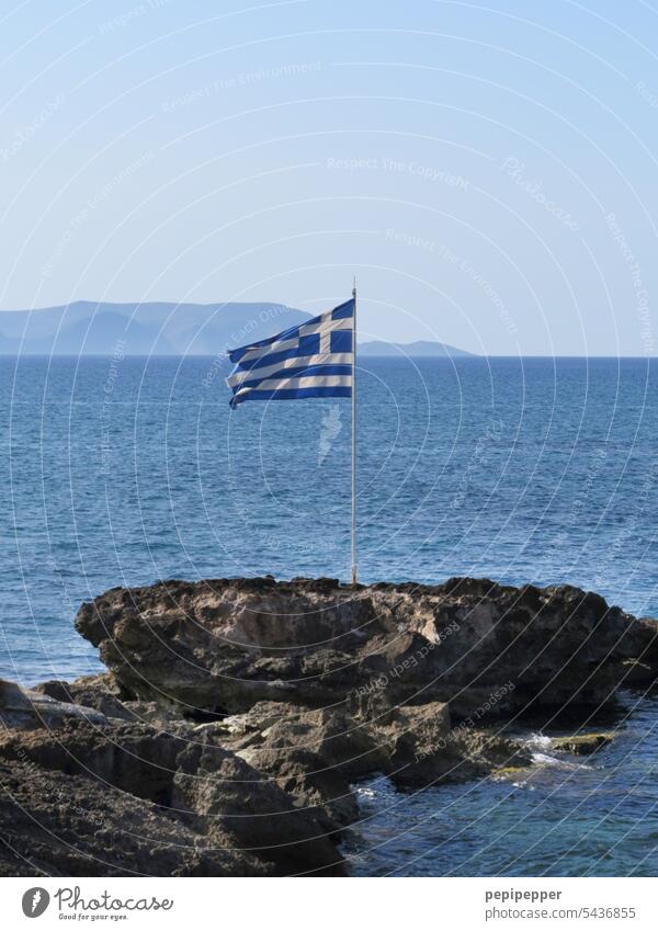 Greek flag on a rock off the coast Ensign Flag Patriotism Wind Judder Greece Greek Islands Flagpole Blue Rock Water coastal landscape Sky Crete