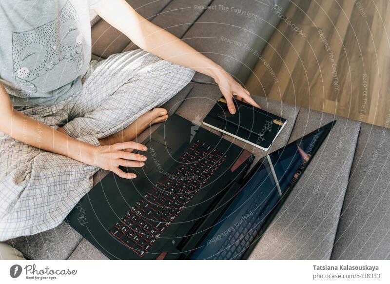 A woman in home clothes uses a laptop Network Internet Connection Laptop female Home office Notebook phone Domestic life Computer people Job mobile person