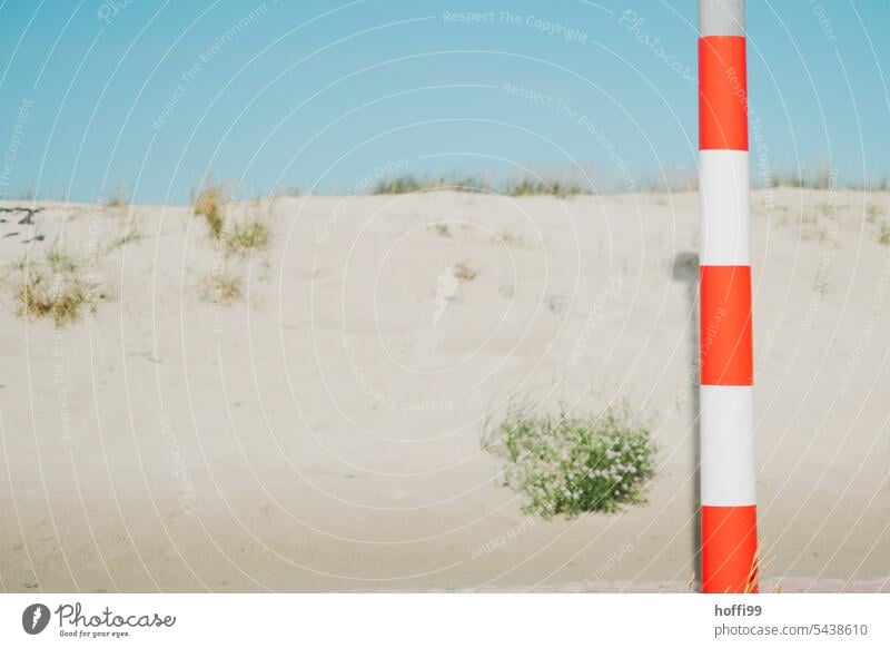 red white pole in front of overgrown sand dune and blue sky Red White stake Sand duene Minimalistic minimalism coast Ocean Beach Blue Sky