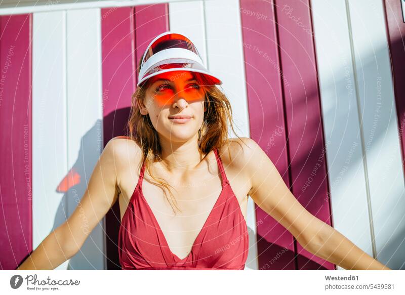 Portrait of young woman with bikini and sun visor smiling smile females women Adults grown-ups grownups adult people persons human being humans human beings