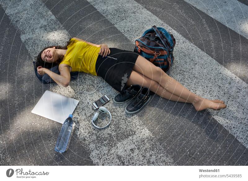Young woman lying on zebra crossing taking a break females women laying down lie lying down resting Adults grown-ups grownups adult people persons human being