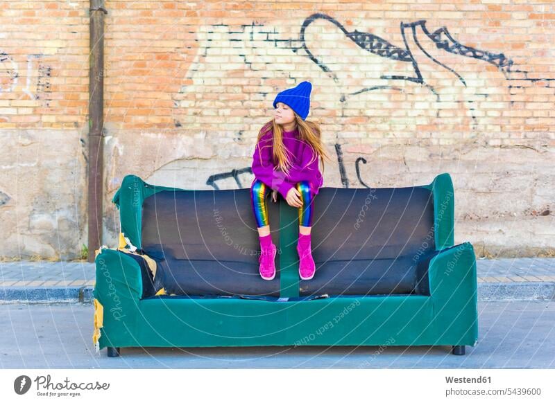 Girl wearing colorful clothing and sitting on a couch outdoors caucasian caucasian ethnicity caucasian appearance european one girl only 1 only one girl 1 girl