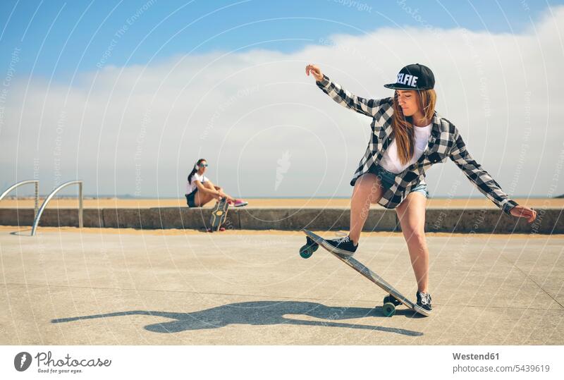 Young woman longboarding while her friend watching her Longboard female skateboarder female skater female skateboarders skaters people persons human being