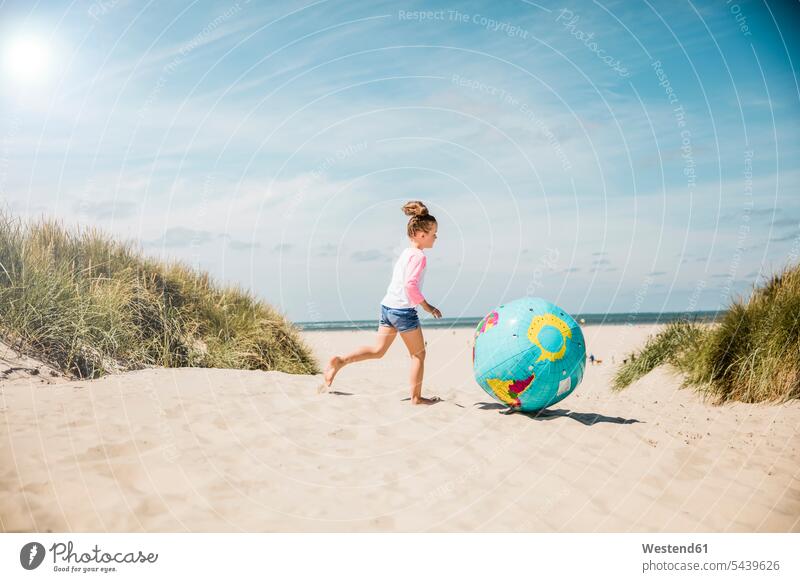 Girl playing with globe on the beach globes girl females girls beaches running child children kid kids people persons human being humans human beings vacation