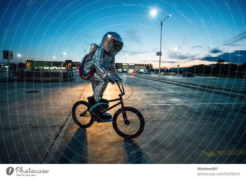 Spaceman in the city at night on parking lot riding bmx bike spaceman spacemen car park parking place by night nite night photography bicycle bikes bicycles BMX