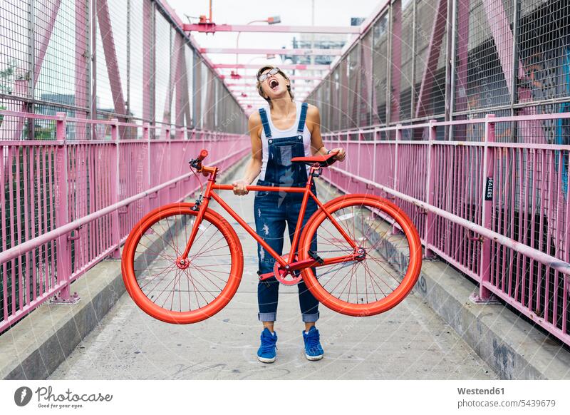 USA, New York City, Williamsburg, woman with red racing cycle on Williamsburg Bridge caucasian caucasian ethnicity caucasian appearance european head back