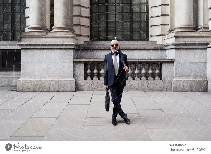 UK, London, portrait of stylish businessman with sunglasses and umbrella wearing suit and tie Businessman Business man Businessmen Business men portraits