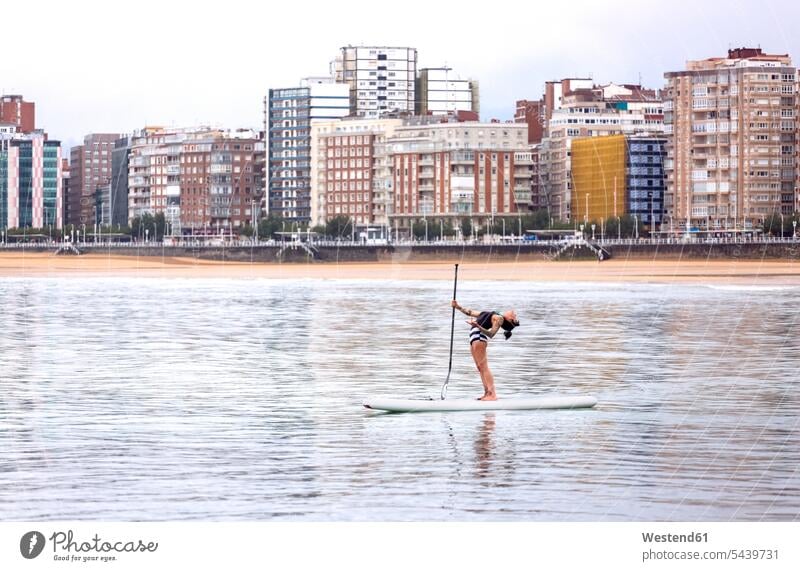 Spain, Gijon, woman practicing paddle board yoga surfboard surfboards water sports Water Sport aquatics mindfulness aware awareness self-care