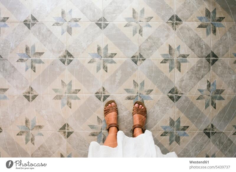 Woman standing on ornate tiled floor tiles ornamented decorating ornamental decorated Part Of partial view cropped ornamentation ornaments point of view