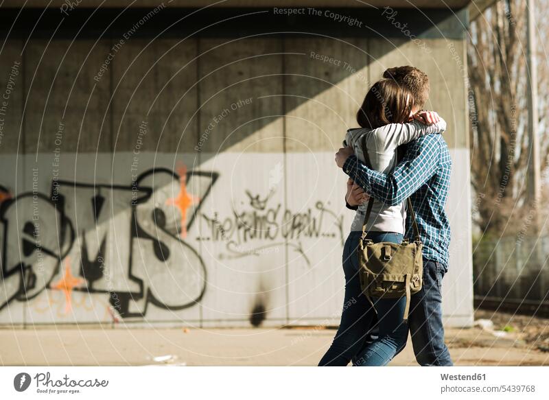 Teenage couple embracing hug hugging embrace togetherness closeness growing up adolesence underpass underpasses first love Pair Falling In Love Teenage Boys