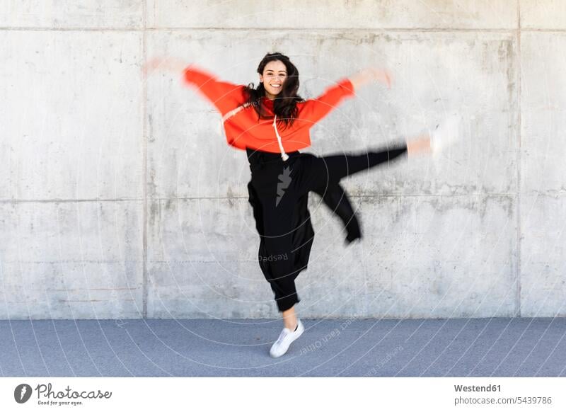 Young contemporary dancer wearing red hoodie shirt in front of a wall Hoodie Hoody woman females women turning dancing blurred motion motion blur Movement