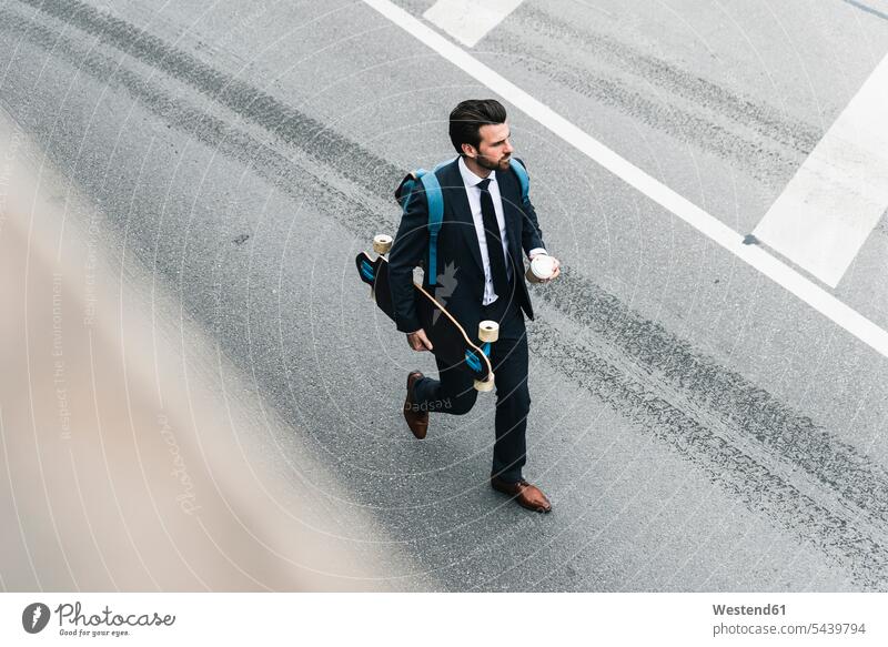 Businessman with takeaway coffee and skateboard walking on the street Business man Businessmen Business men Skate Board skateboards going Coffee road streets