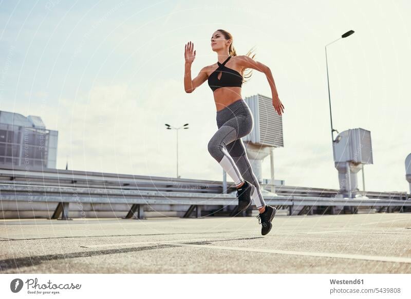 Young woman doing running exercises in the city exercising training practising Jogging females women fitness sport sports Adults grown-ups grownups adult people