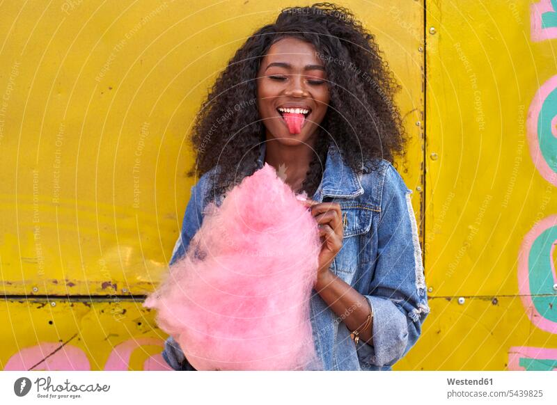 Portrait of smiling young woman with pink candyfloss sticking out tongue human human being human beings humans person persons African black black ethnicity