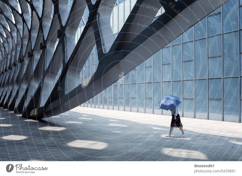 China, Shenzhen, modern architecture and walking woman Protection protecting building buildings pedestrian loneliness lonely solitude Anonymity anonymous