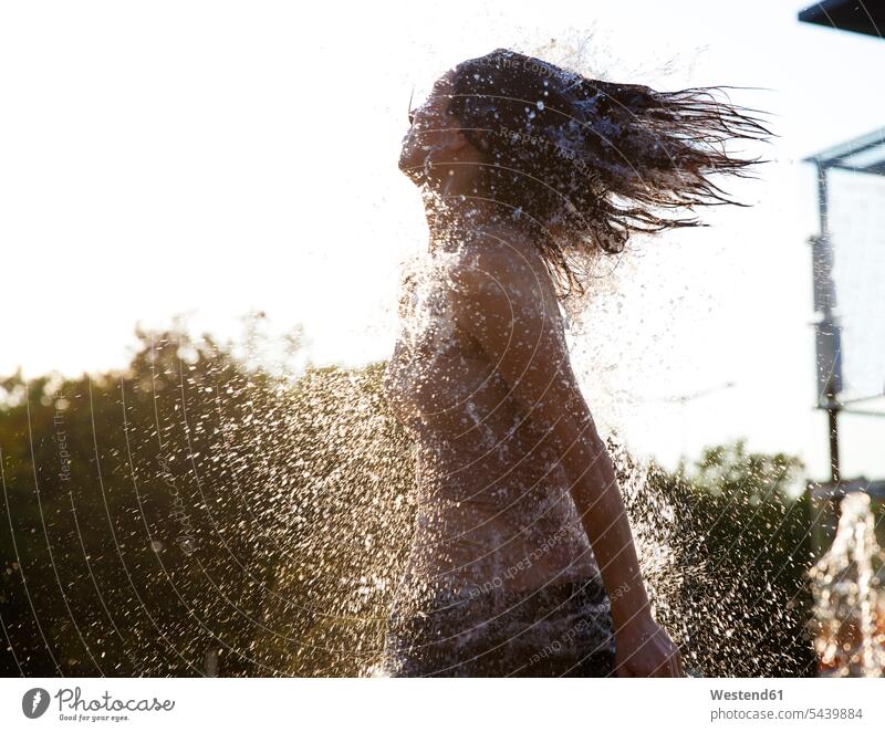 Woman running through fountain splashing water drops 30-35 years 30 to 35 years energy power wet wetness Refreshment refreshing copy space summer summertime