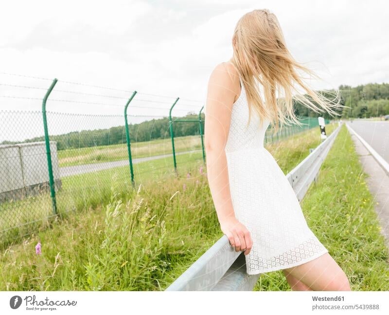 Young woman in white dress standing at the roadside Road Side females women streets Adults grown-ups grownups adult people persons human being humans