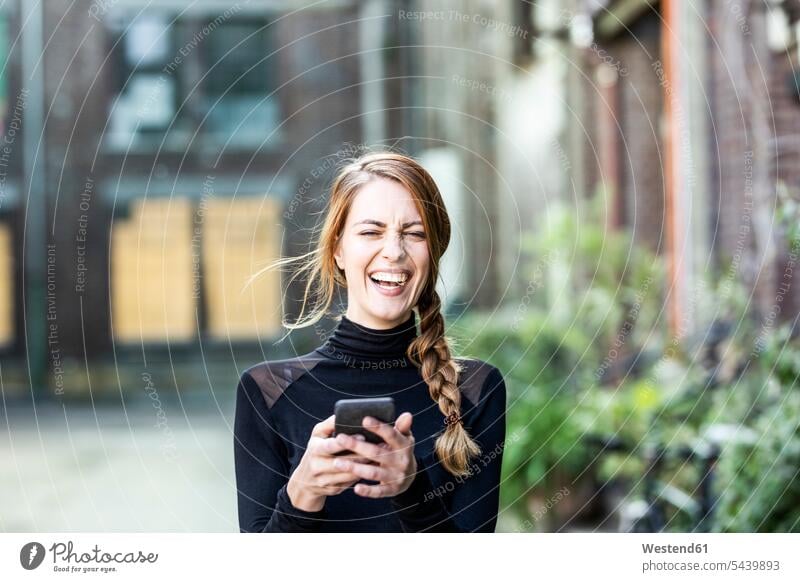 Portrait of laughing woman with smartphone females women Laughter Smartphone iPhone Smartphones Adults grown-ups grownups adult people persons human being