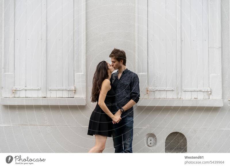 Young couple in love kissing in front of building kisses twosomes partnership couples buildings people persons human being humans human beings built structure