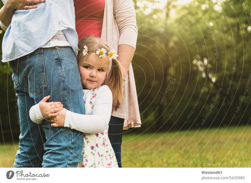 Girl embracing father's leg on meadow Lampertheim young women young woman girl girls female females nature hugging cuddling Part Of partial view two parents