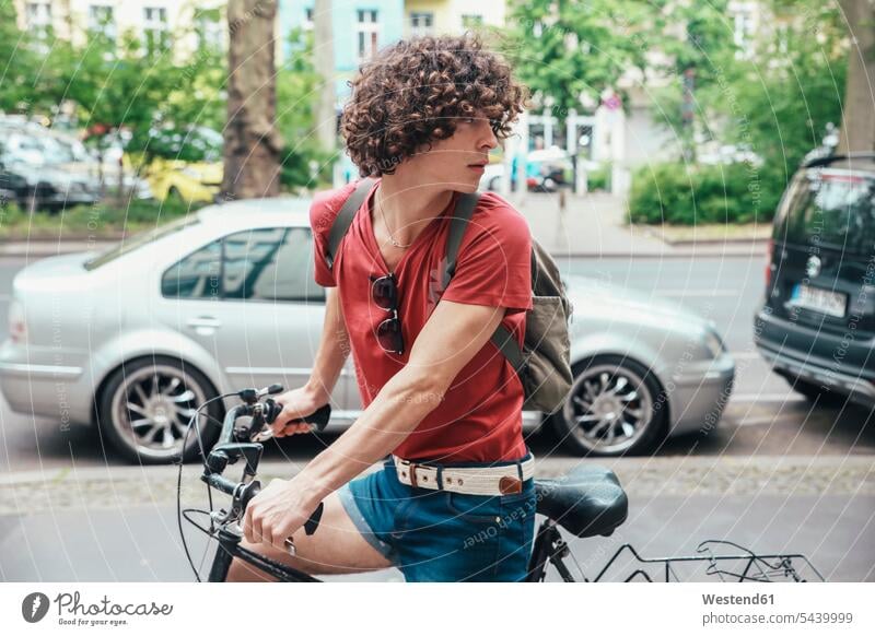 Young man riding bicycle on pavement turning around driving drive Side Walk bikes bicycles males Adults grown-ups grownups adult people persons human being