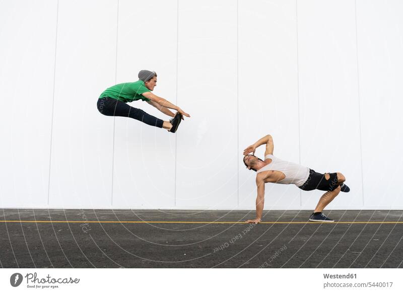 Two acrobats doing tricks together, jumping mid-air exercise exercises practising exercising equilibrists Leaping jumps different Individuality Fun having fun
