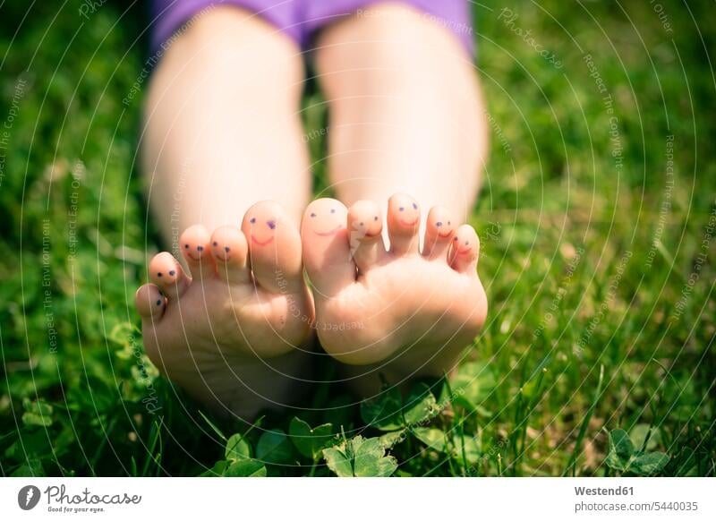 Little girl's feet with painted toes lying in grass nature leisure free time leisure time Humour Humorous green background close-up closeups close-ups close up