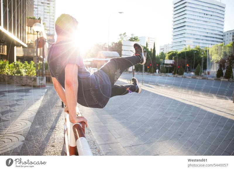 Spain, Madrid, man jumping over a fence in the city during a parkour session active Parkour Free Running Leaping men males sport sports leisure free time