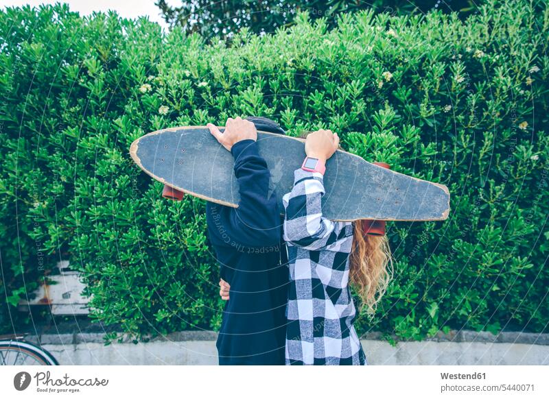 Couple hiding behind skateboard Skate Board skateboards Love loving hide couple twosomes partnership couples positive Emotion Feeling Feelings Sentiments