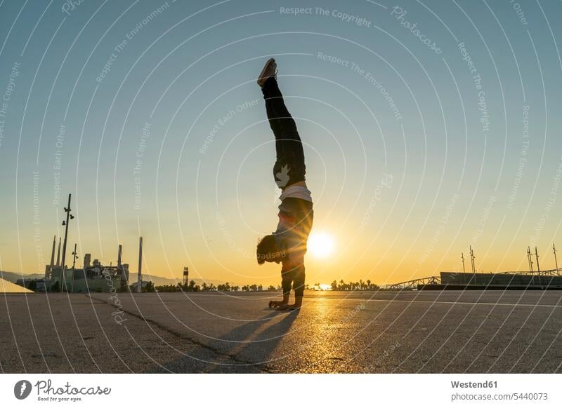 Acrobat doing handstand in the city at sunrise handstands acrobat acrobats equilibrists sun rise sunrises athlete Sportspeople Sportsman Sportsperson athletes