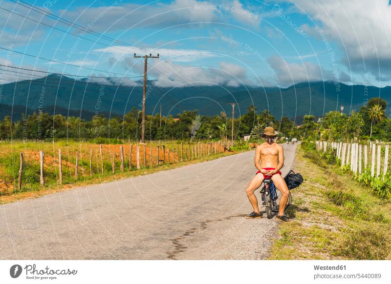 Laos, Vang Vieng, young man with bicycle in the road bikes bicycles streets roads men males transportation Adults grown-ups grownups adult people persons
