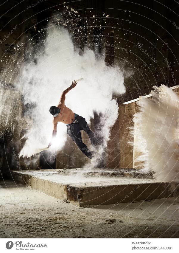 Man jumping in flour dust cloud during freerunning exercise man men males Leaping exercises Adults grown-ups grownups adult people persons human being humans