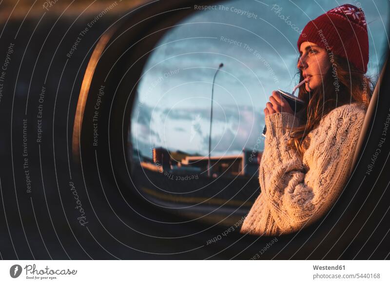 Iceland, young woman with coffee to go at sunset, mirrored in wing mirror on the move on the way on the go on the road Side-View Mirror Side-View Mirrors Coffee