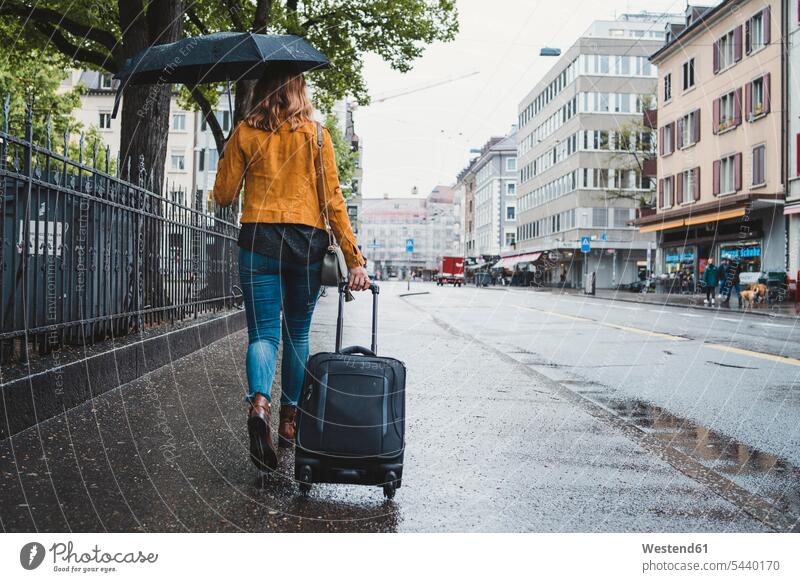 Young woman walking in the city on a rainy day, Zurich, Switzerland human human being human beings humans person persons caucasian appearance