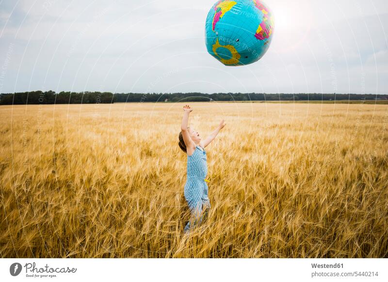 Girl standing in grain field playing with globe globes Grain field Cornfield Corn Field Cornfields Corn Fields farmland happiness happy girl females girls child