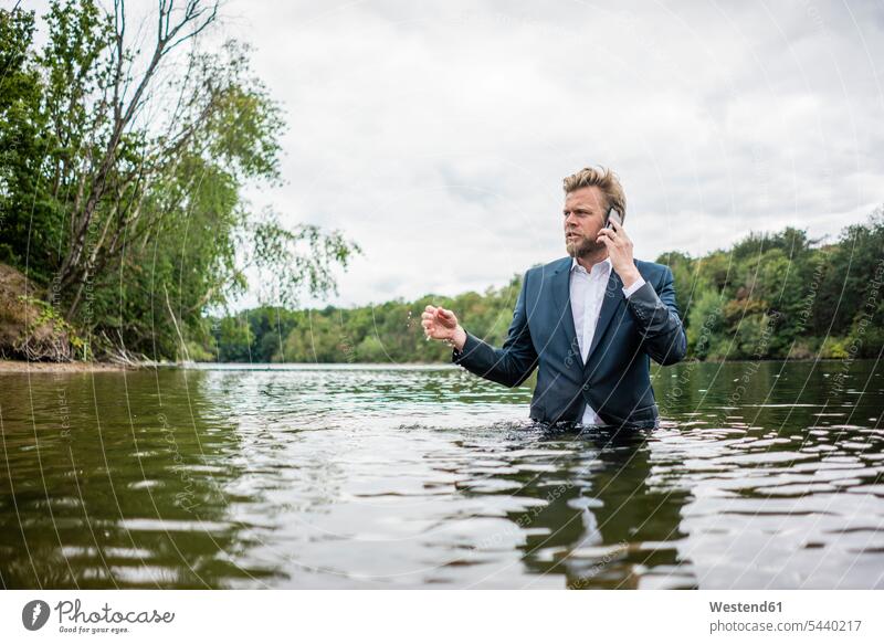 Businessman standing in a lake talking on the phone business life business world business person businesspeople Business man Business men Businessmen