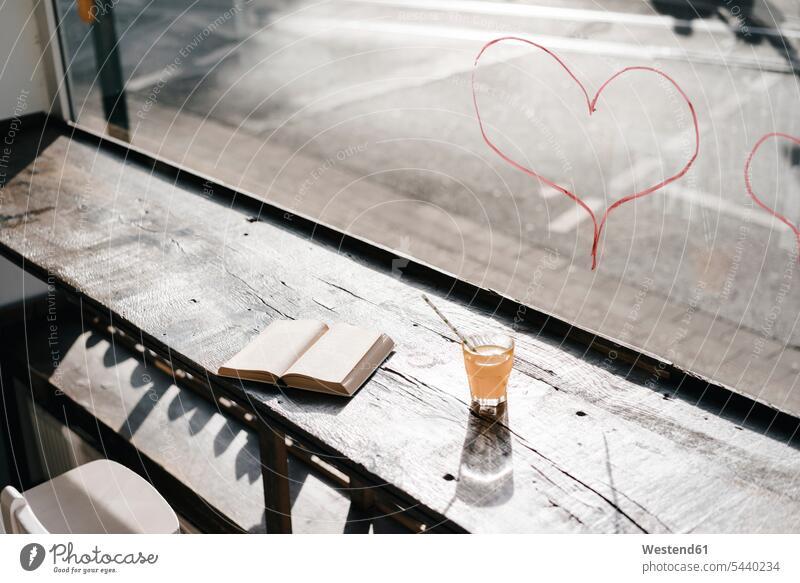 Book and drink on table in front of a window with lipstick hearts reading enjoying indulgence enjoyment savoring indulging pleasure nobody Lipstick Lipsticks