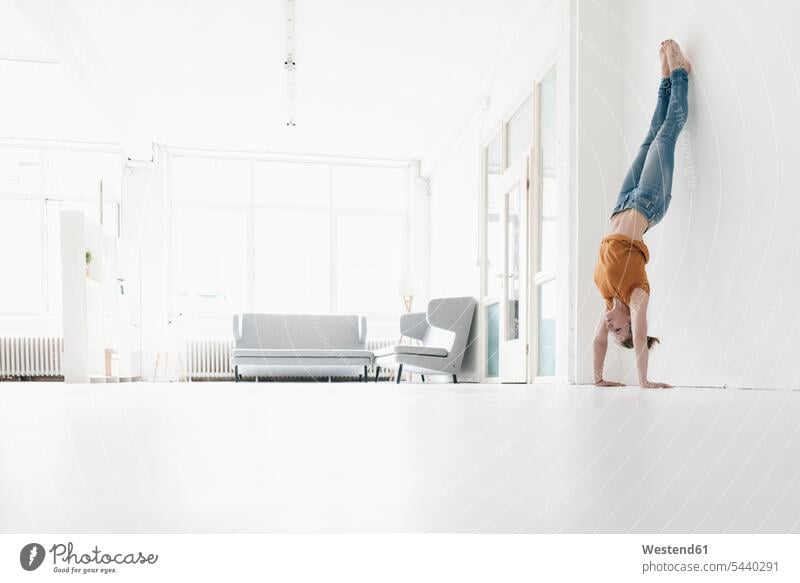 Woman doing handstand in a loft woman females women lofts handstands Adults grown-ups grownups adult people persons human being humans human beings copy space