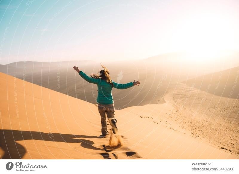 Namibia, Namib Desert, Sossusvlei, Woman running down the Dune 45 at sunrise caucasian caucasian ethnicity caucasian appearance european nature natural world