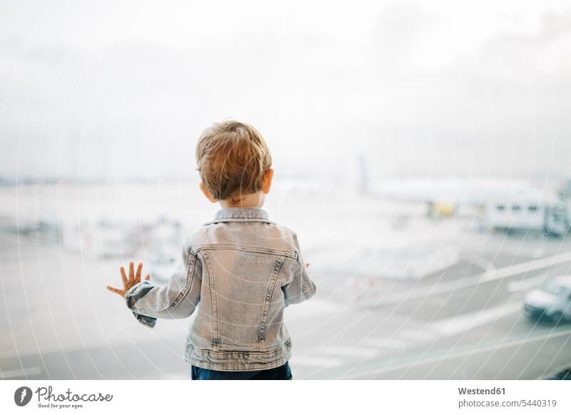 Spain, Barcelona, back view of little boy looking through window at the airport caucasian european caucasian ethnicity caucasian appearance waiting indoors