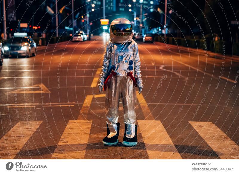 Spaceman standing on a street in the city at night astronaut astronauts by night nite night photography town cities towns road streets roads spaceman spacemen