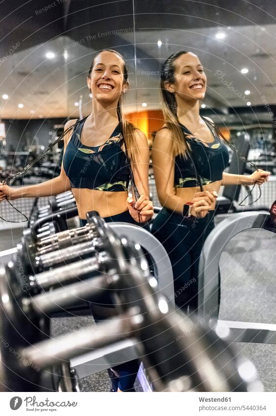 Portrait of a happy young woman after working out in gym exercising exercise training practising females women smiling smile gyms Health Club Adults grown-ups