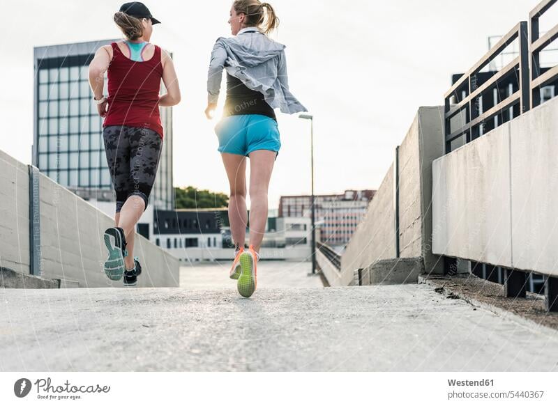 Two women running in the city Jogging female friends woman females fitness sport sports mate friendship Adults grown-ups grownups adult people persons
