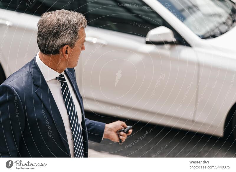 Businessman using remote control key of car car key car keys Business man Businessmen Business men remote controles business people businesspeople