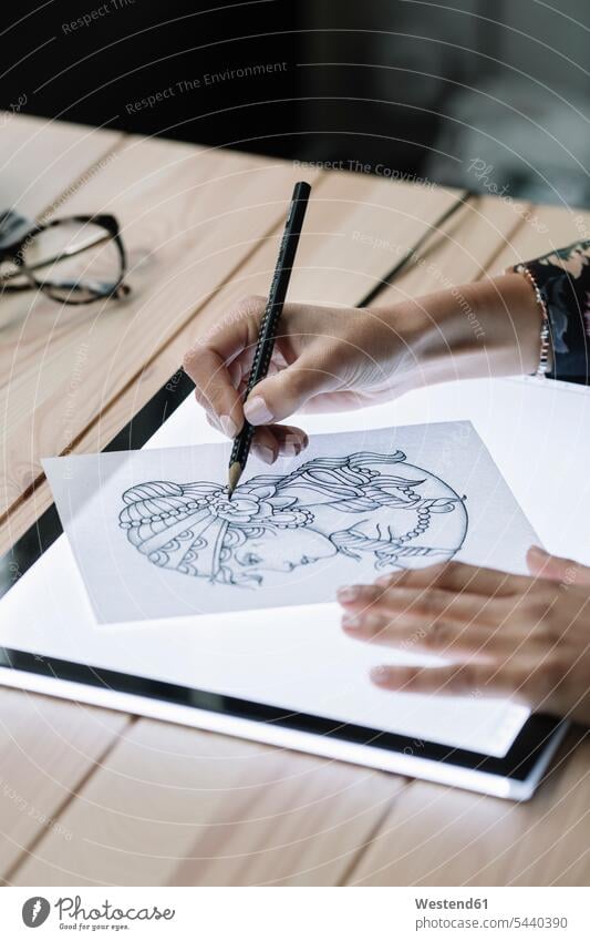 Woman's hand drawing template on light table woman females women light box layout table templates human hand hands human hands sketching Adults grown-ups