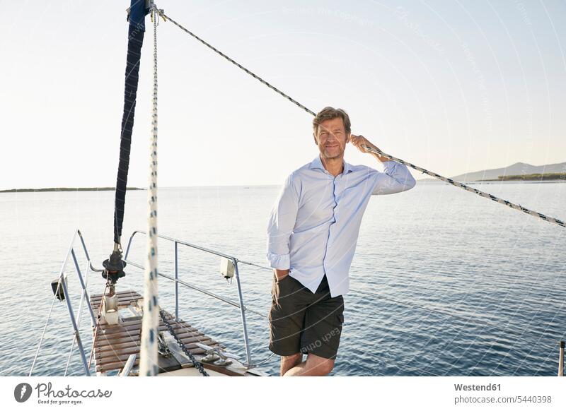 Portrait of realxed mature man on his sailing boat men males Adults grown-ups grownups adult people persons human being humans human beings boat sports sailboat