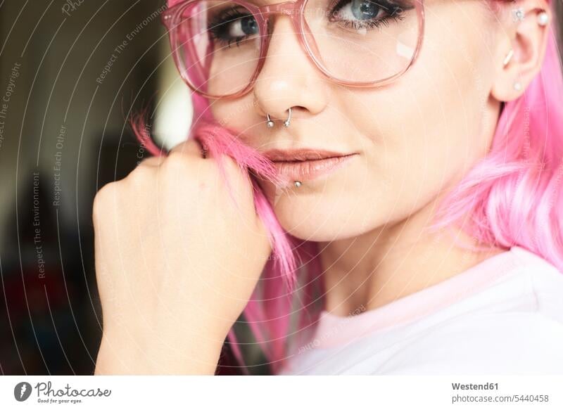 Portrait of young woman with pink hair, glasses and piercings specs Eye Glasses spectacles Eyeglasses portrait portraits females women Adults grown-ups grownups