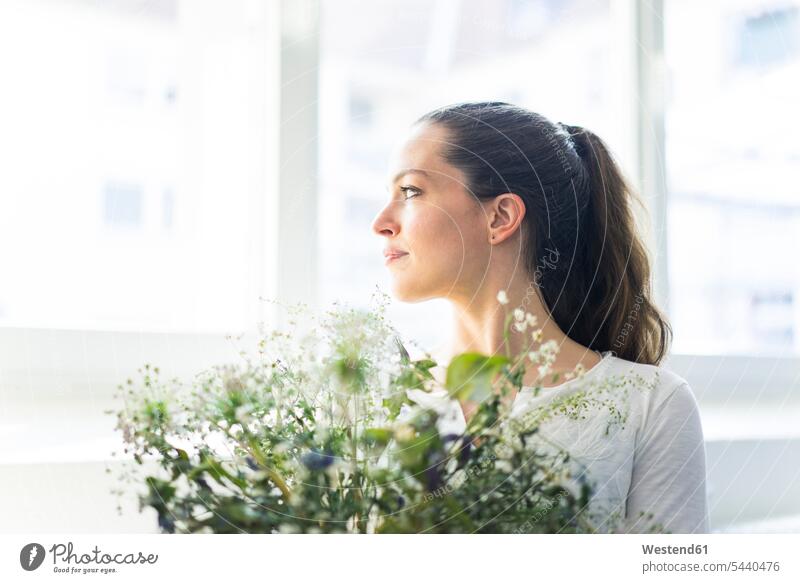 Woman with flowers looking out of window Flower Flowers woman females women windows looking away look away Plant Plants Adults grown-ups grownups adult people