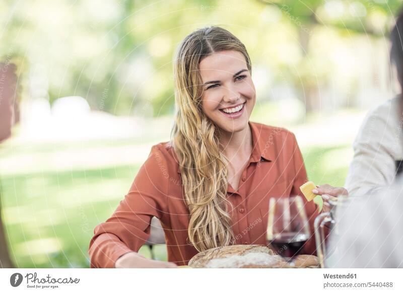 Smiling woman at family lunch in garden celebrating celebrate partying Wine Red Wine Red Wines smiling smile group of people Group groups of people friends